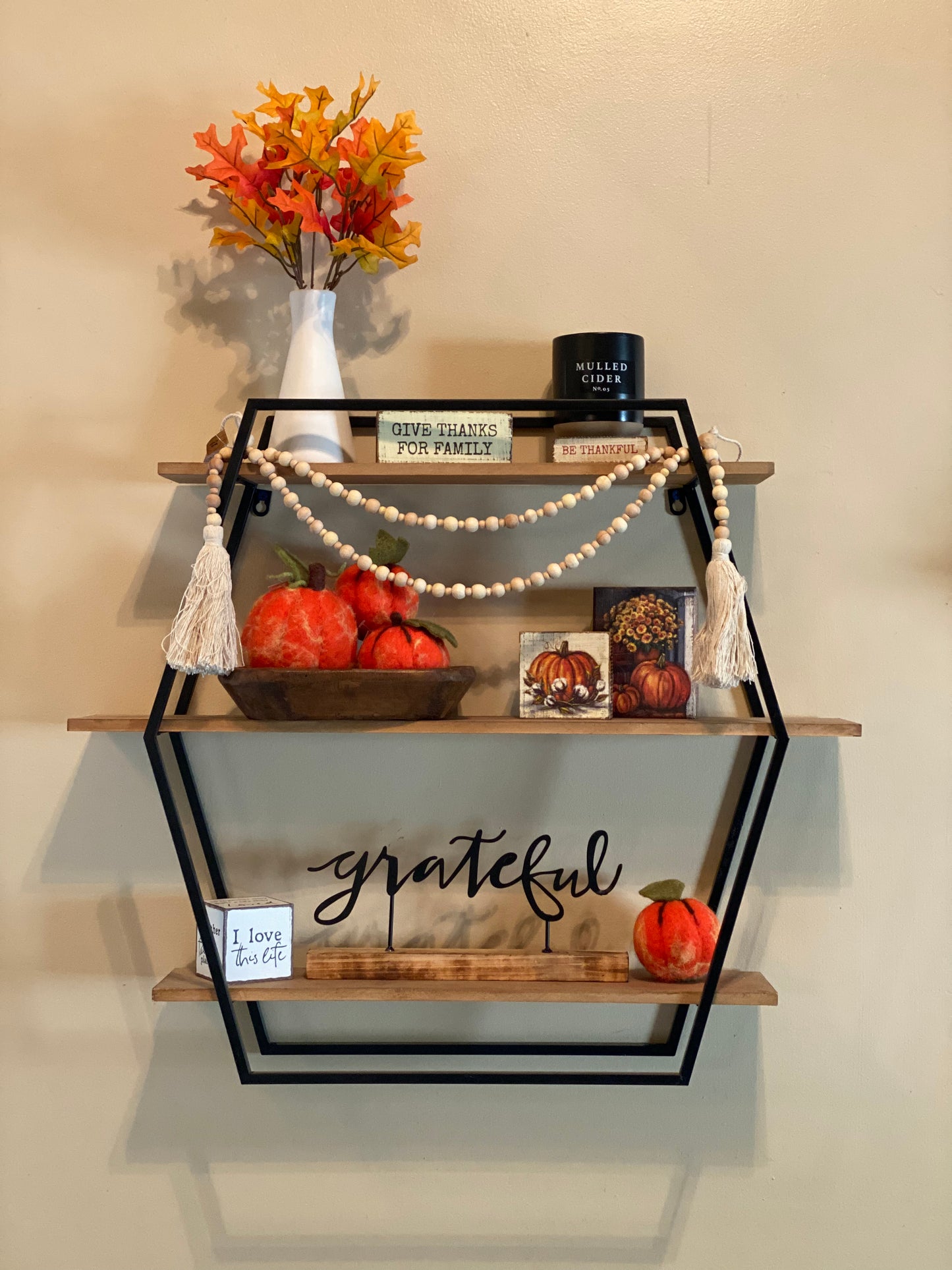 fall display with garland, signs, and candle