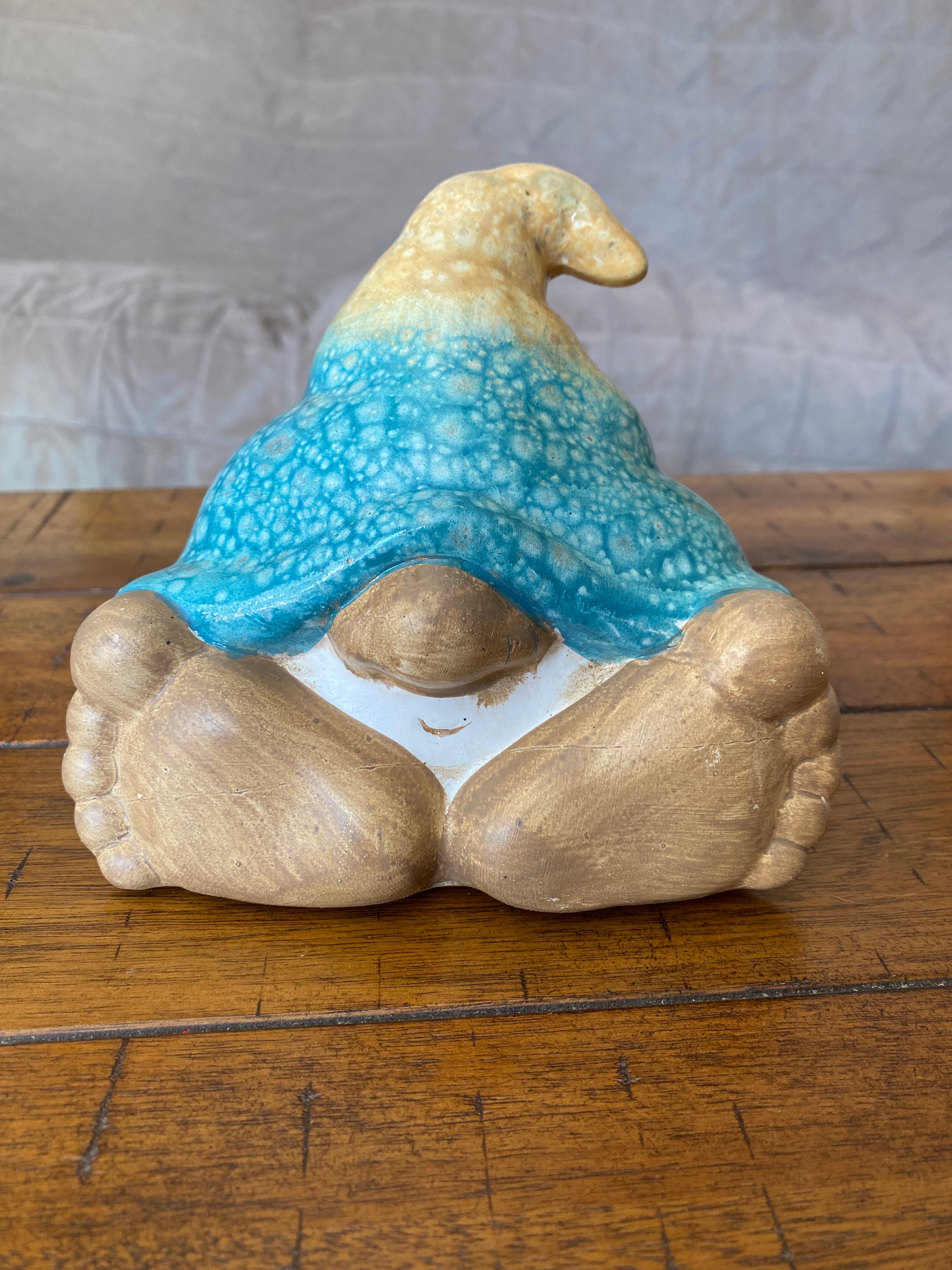 5 inch gnome with tan and blue hat, small face, and large feet